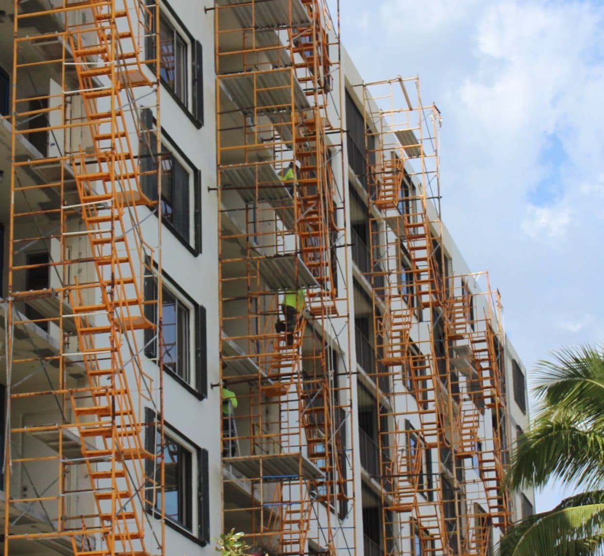 A condominium building fully wrapped in scaffolding during exterior restoration