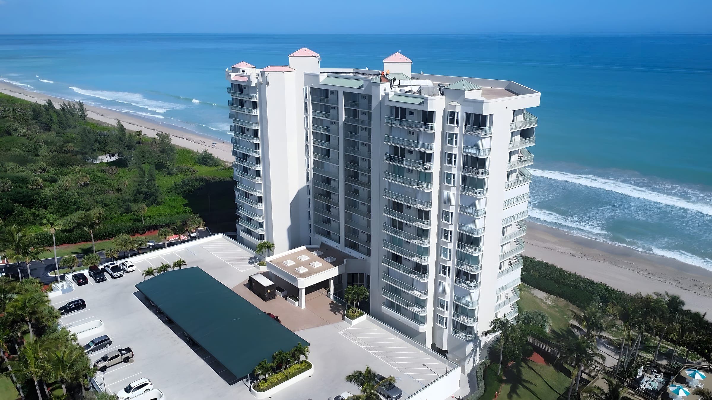 Aerial view of an oceanfront condominium tower and beach on the Florida coast