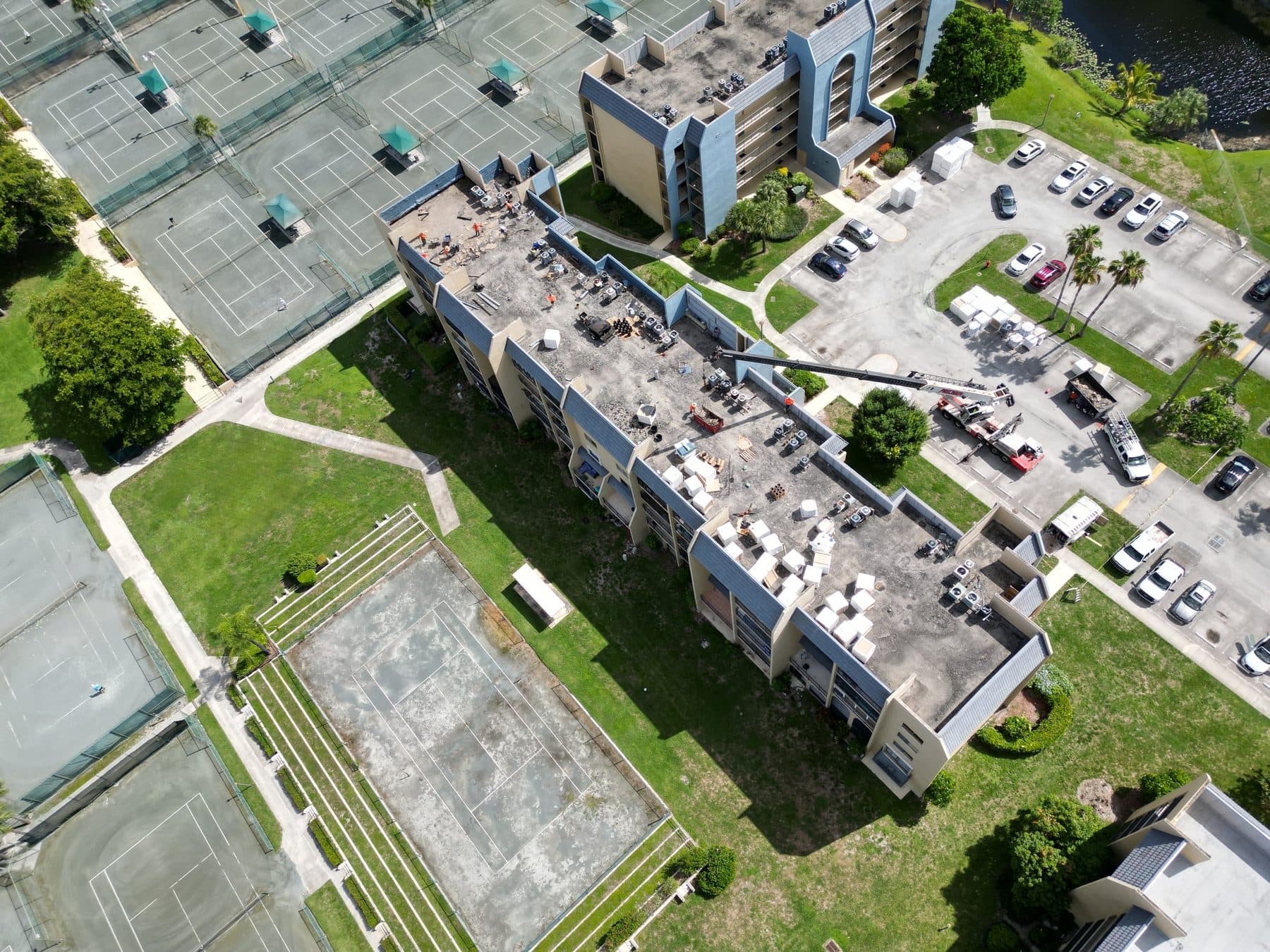 Aerial view of a multi-family building mid roof replacement, with crews working across the deck