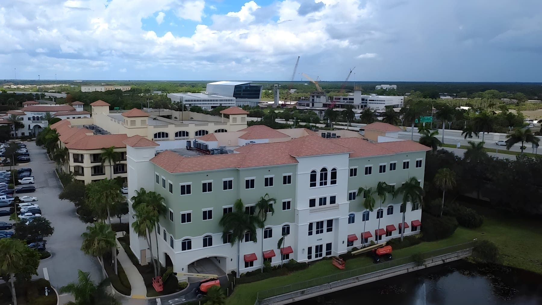 Aerial view of a professional office building with boom lifts staged for exterior work