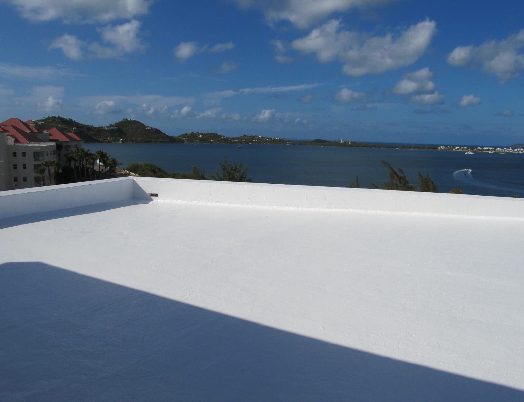 A completed white roof coating on a waterfront commercial building