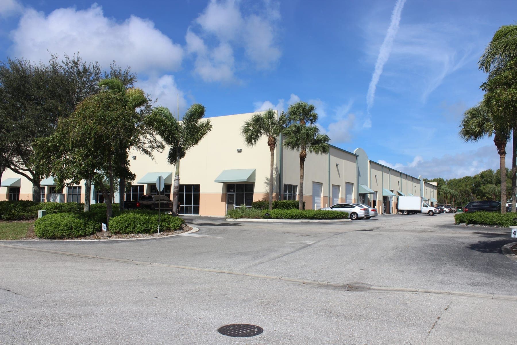 The concrete-block buildings at Westroads Industrial Park, with green awnings over the glass storefronts and roll-up bay doors along the front